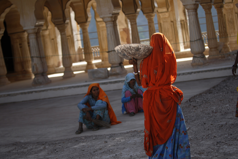 Located high on a hill, it is the principal tourist attraction the Amber Fort near Jaipur is known for its artistic style elements. With its large ramparts and series of gates and cobbled paths, the fort overlooks Maota Lake, which is the main source of water and in this photograph an Indian woman carrying stone at this fort.