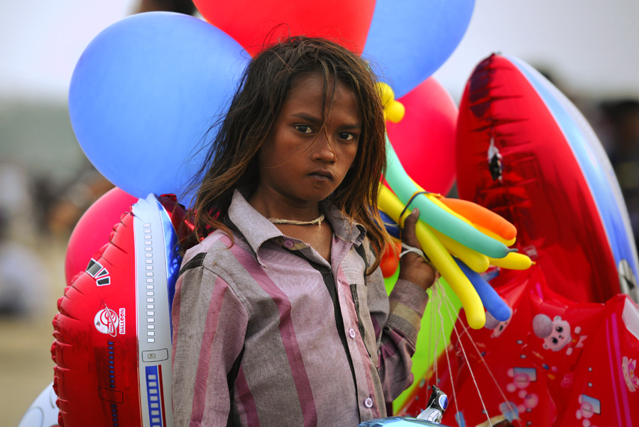 Child labour is the practice of having children engage in economic activity, on part- or full-time basis. The practice deprives children of their childhood and is harmful to their psysical and mental development. Poverty, lack of good schools and growth of informal economy are considered as the important causes of child labour in India. In this photograph a boy is selling his balloons at the Juhu Beach in Mumbai, India.