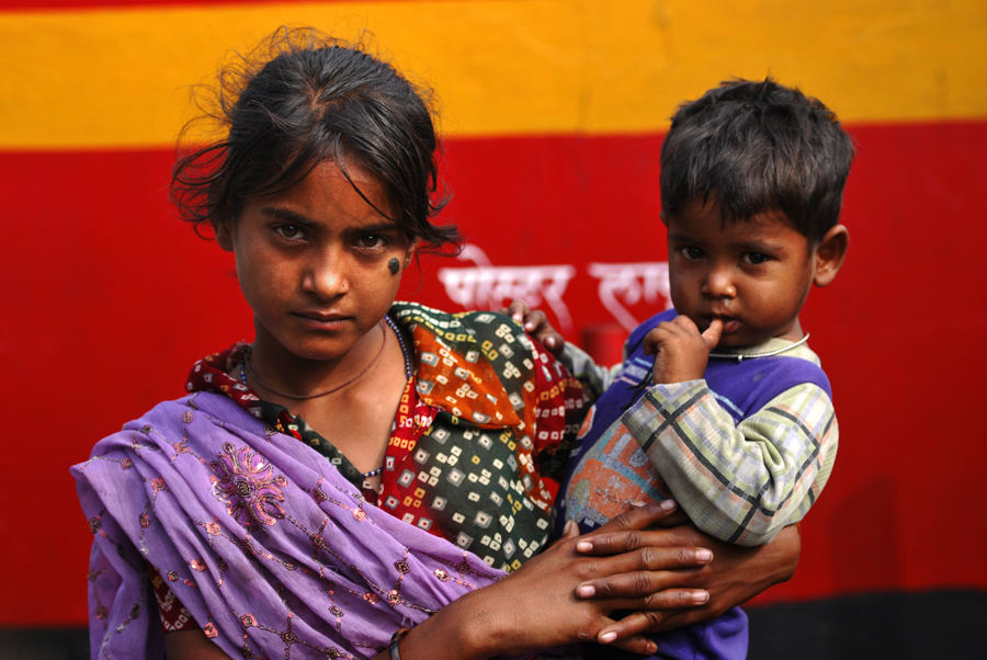 A street child is seen with one of her younger siblings on the Dadabhai Naoroji Road in Mumbai, India. Mainly because of family conflict, street children come to live on the streets and take on the full responsibilities of caring for themselves, including working to provide for and protecting themselves.