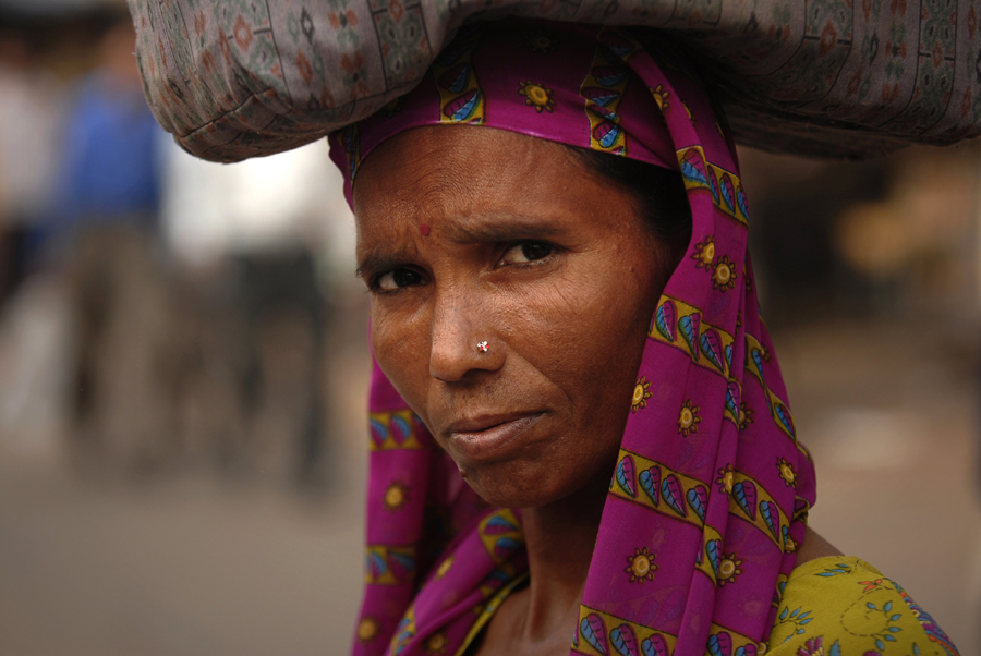 In this photograph an Indian woman is carrying goods on her head in Delhi, India. A job, employment, work or occupation, is a person's role in society. More specifically, a job is an activity, often regular and often performed in exchange for payment for a living. Many people have multiple jobs for instance as a parent, a homemaker and an employee.