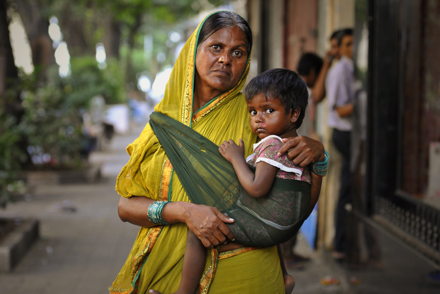A mother is carrying a child in her arms in the Colaba area of Mumbai, India. In Mumbai in particular, visitors are often approached by a child or woman wanting some powdered milk to feed a baby and they will assist you to a nearby stall or shop that conveniently happens to sell tins or boxes of such 'Milk'. But when you are buying milk powder this way you might be encouraging a scam.