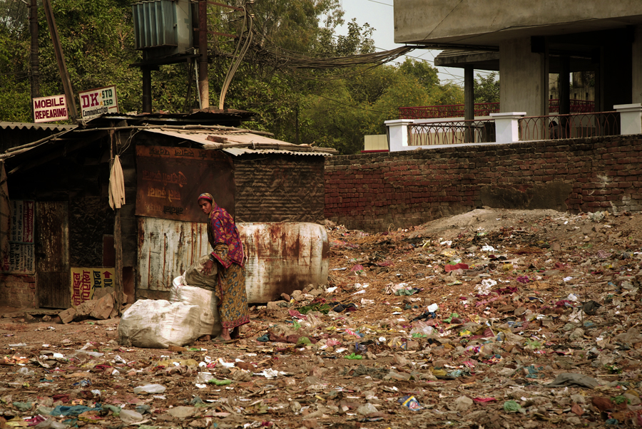 A heavily populated urban area characterized by substandard housing and squalor and the slum areas are characterized by substandard housing structures. Shanty homes are often built hurriedly with materials unsuitable for housing. Often the construction quality is inadequate to withstand heavy rains, high winds, or other local climate and location. Paper, plastic, earthen floors, mud-and-wattle walls, wood held together by ropes, straw or torn metal pieces as roofs are some of the materials of construction.